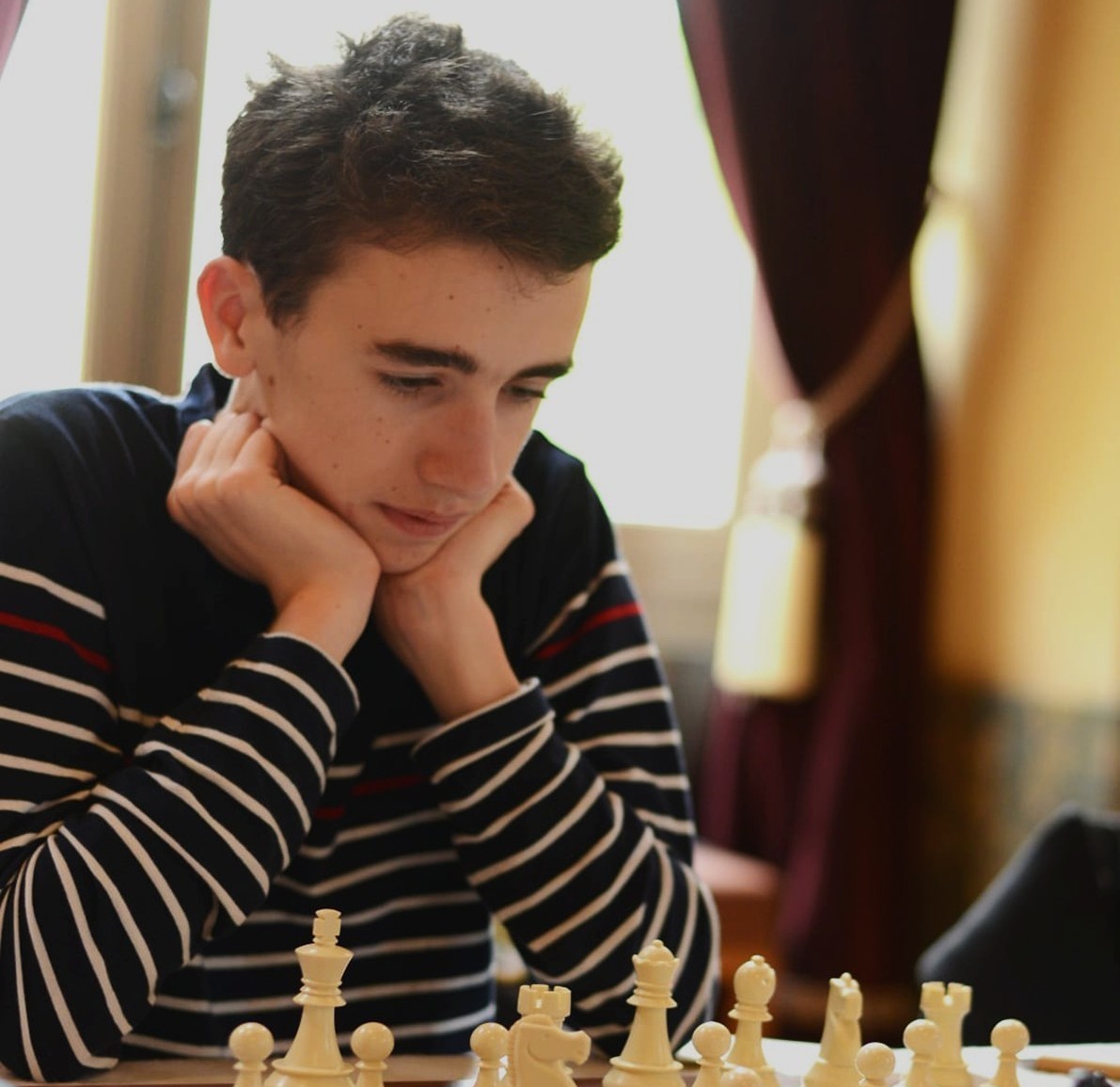 Portrait de Guillaume Garde réfléchissant devant un échiquier pendant une partie